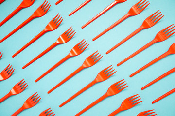 red plastic forks on blue background