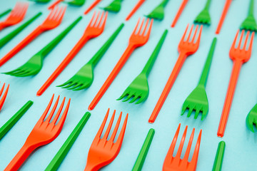 green and red plastic forks on blue background