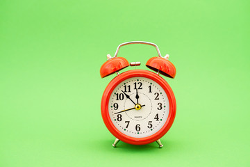 red alarm clock on green background