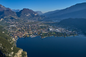 Aerial view of the city of Riva del Garda, Italy. Panoramic view of Lake Garda in the foreground, the city is surrounded by rocks and alpine mountains. Autumn season.