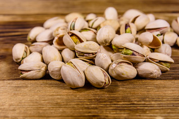 Pile of pistachio nuts on a wooden table