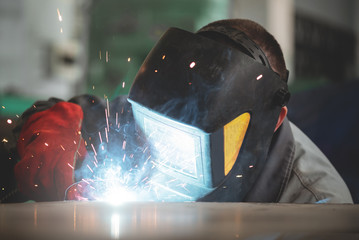 Welder is welding a metal frame.