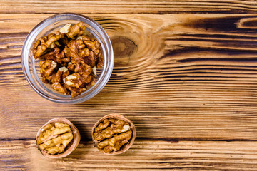 Cores of walnut in glass bowl on a wooden table. Top view