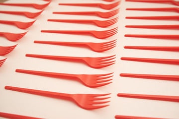 red plastic forks on white background
