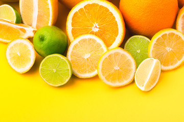 Naklejka na ściany i meble Citrus fruits (orange, lemon, grapefruit, lime) on yellow background. Summer concept. Set of tropical fruits