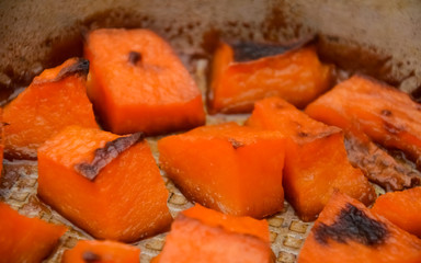  Pieces of sweet pumpkin baked with sugar for Halloween dinner. Healthy Vegetarian food. Autumn warm dish as a dessert. Selective focus, close-up. copy space.