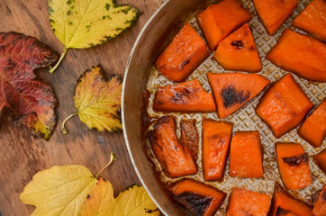  Pieces of sweet pumpkin baked with sugar for Halloween dinner. Healthy Vegetarian food. Autumn warm dish as a dessert. Selective focus, close-up. copy space.