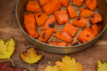  Pieces of sweet pumpkin baked with sugar for Halloween dinner. Healthy Vegetarian food. Autumn warm dish as a dessert. Selective focus, close-up. copy space.