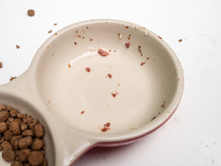 Dirty cat food bowls on a mucky white surface