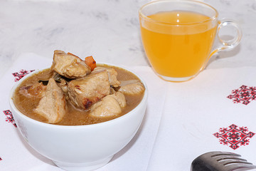 Meat goulash in a light cup and a mug with lemon juice, the basis of diet food, protein diet,...