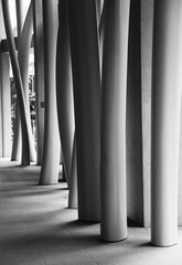 Vertical grayscale shot of a modern building's interior with crooked columns