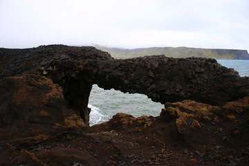 Fototapeta premium Puente de piedra en la costa con vista del mar en Islandia