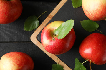 Apples and cutting board on wooden background, top view