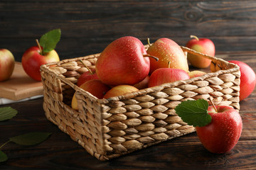 Basket with apples on wooden background, copy space