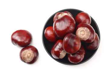 chestnuts in a black plate isolated on white background. top view