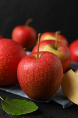 Apples and kitchen towel on black background, close up