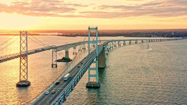 Aerial drone footage of Cheasapeake Bay Bridge, with slow forward camera movement, along the bridge, towards sunset