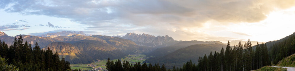 Mount Dachstein, the famous Gosaukamm and the village Gosau in Gosauvalley on a sunny summer evening. The sun is illuminating the peaks in a lovely orange color.