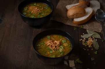 Vegan lentil, okra and peas soup, topped with crispy onions, served in black bowls