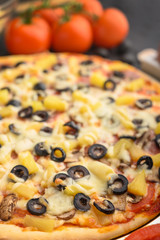 Italian pizza with ingredients on a dark background. Vertical photo.