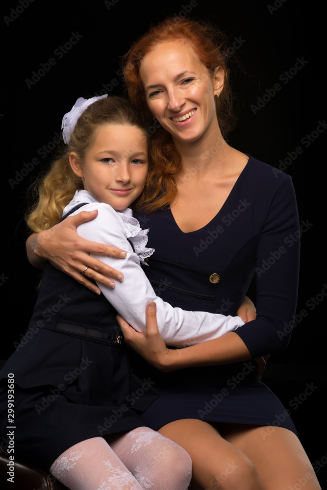 Wall mural mom and little daughter studio portrait.on black background