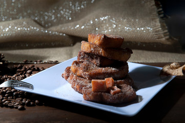 Brazilian Christmas dinner. French toast, plum fruit, dried apricot. Brazilian Christmas tradition. Brown background. Seen from above. Closely. Horizontal.