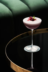 Classic cocktail glass on glass table in night club restaurant, close-up