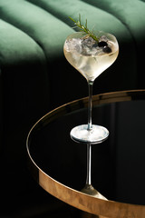 Classic cocktail glass on glass table in night club restaurant, close-up