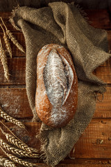 Freshly baked wheat bread, homemade cakes, still life with bread, crisp loaf of bread, still life on a rustic background, top view, rustic bread, roll, loaf.