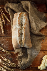 Freshly baked wheat bread, homemade cakes, still life with bread, crisp loaf of bread, still life on a rustic background, top view, rustic bread, roll, loaf.