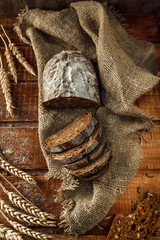 Freshly baked wheat bread, homemade cakes, still life with bread, crisp loaf of bread, still life on a rustic background, top view, rustic bread, roll, loaf.