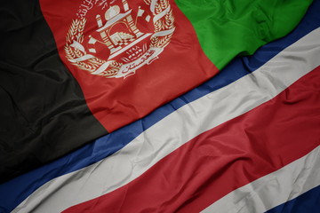waving colorful flag of costa rica and national flag of afghanistan.