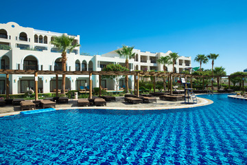 swimming pool with coconut tree and white umbrella
