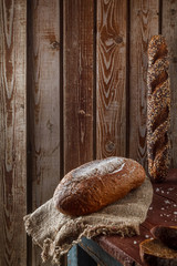 Freshly baked wheat bread, homemade cakes, still life with bread, crisp loaf of bread, still life on a rustic background, top view, rustic bread, roll, loaf.