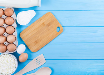 Dairy products on wooden table. Milk, cheese, egg, curd cheese and butter.