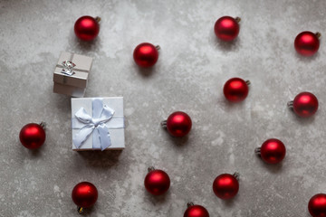 Naklejka na ściany i meble White gift box with white ribbon bow and vinous christmas balls around, isolated on gray background