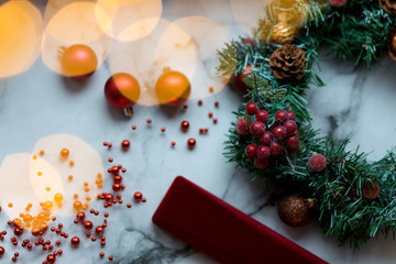 Decorated Christmas wreath with cones and beads, on a stone background