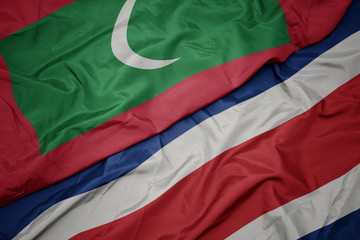waving colorful flag of costa rica and national flag of maldives.