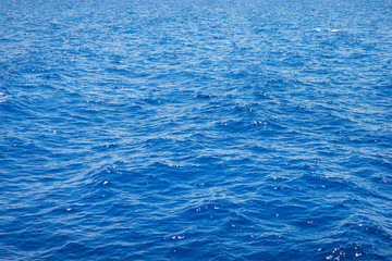 Sea background . Blue water with sun reflections