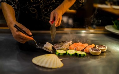teppan show in a Japanese restaurant, cooking directly in front of the client, fish, rice, meat, vegetables