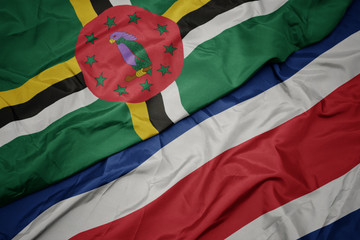 waving colorful flag of costa rica and national flag of dominica.