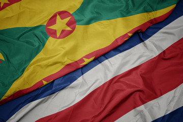 waving colorful flag of costa rica and national flag of grenada.