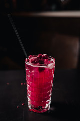 red alcohol coctail on the table with raspberry