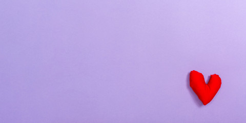 Valentine's day heart shaped pillow on a purple paper background