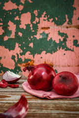 Ripe red onions on a rustic wooden background. Food ingredients. Onion peel. Selective focus. Place for text.