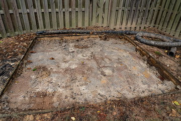 Dirt and gravel formed the base of a patio in a residential backyard.