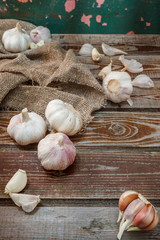 Fresh garlic, head of garlic, bulb of garlic, cloves of garlic on an old rustic wooden background. Place for text. The concept of a healthy diet. Vitamins.