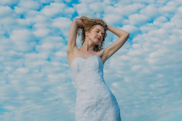 Fototapeta na wymiar Portrait of bride with closed eyes among clouds