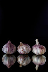 Fresh garlic, head of garlic, bulb of garlic, cloves of garlic on an old rustic wooden background. Place for text. The concept of a healthy diet. Vitamins.