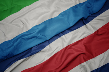 waving colorful flag of costa rica and national flag of sierra leone.